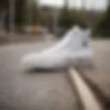 The iconic all white Converse Chuck Taylor sneakers on a skateboard