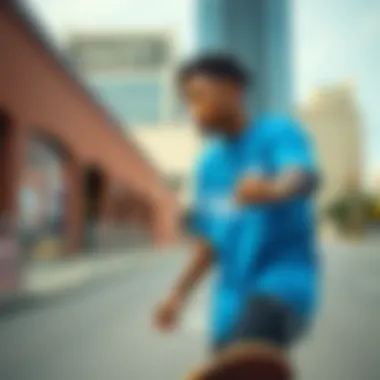 Skateboarder in motion wearing a Carolina blue graphic tee in an urban setting