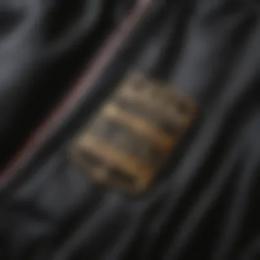 Close-up of the fabric and stitching of a black letterman jacket, showcasing its quality.