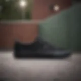 Black Vans sneakers on a skateboard