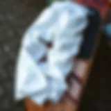 A pair of stylish white baggy pants laid out on a skateboard deck