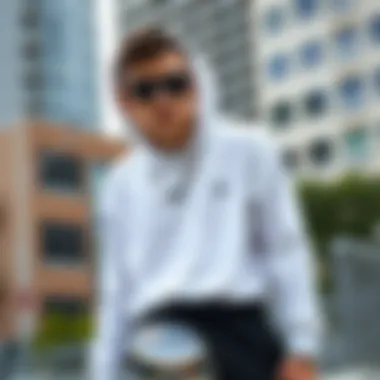 Stylish skateboarder wearing a white hooded long sleeve shirt in an urban setting
